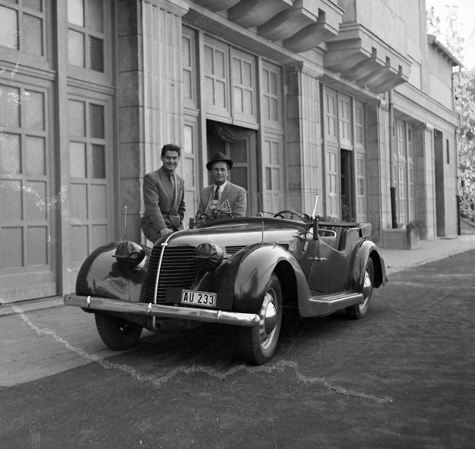 Szilassy László autója mellett titkárával a Hunnia Filmgyár épülete előtt 1942-ben. Forrás: Fortepan / Kotnyek Antal